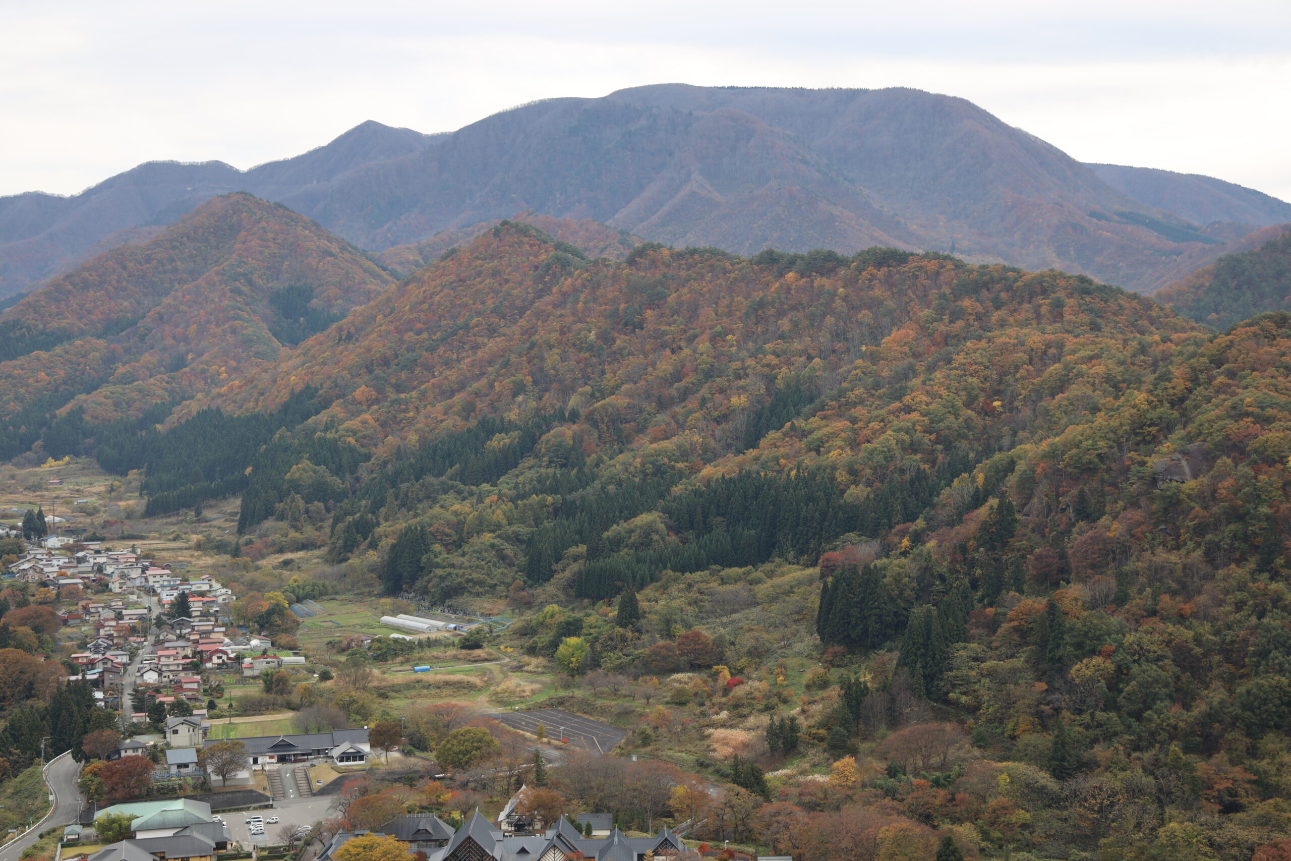 紅葉に包まれた山寺周辺の山並み
