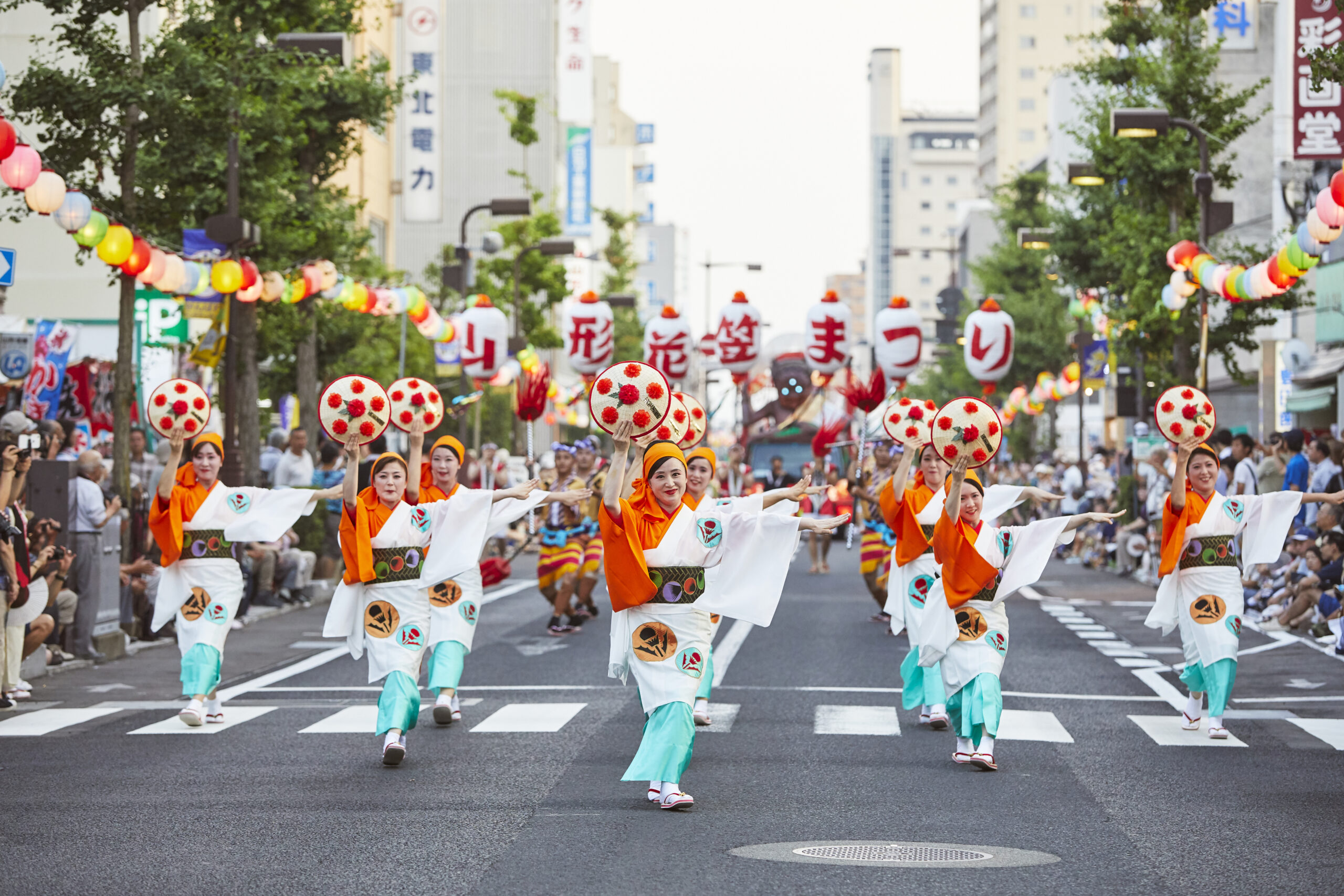 紅花を飾った花笠を手に踊る山形花笠まつりの踊り手